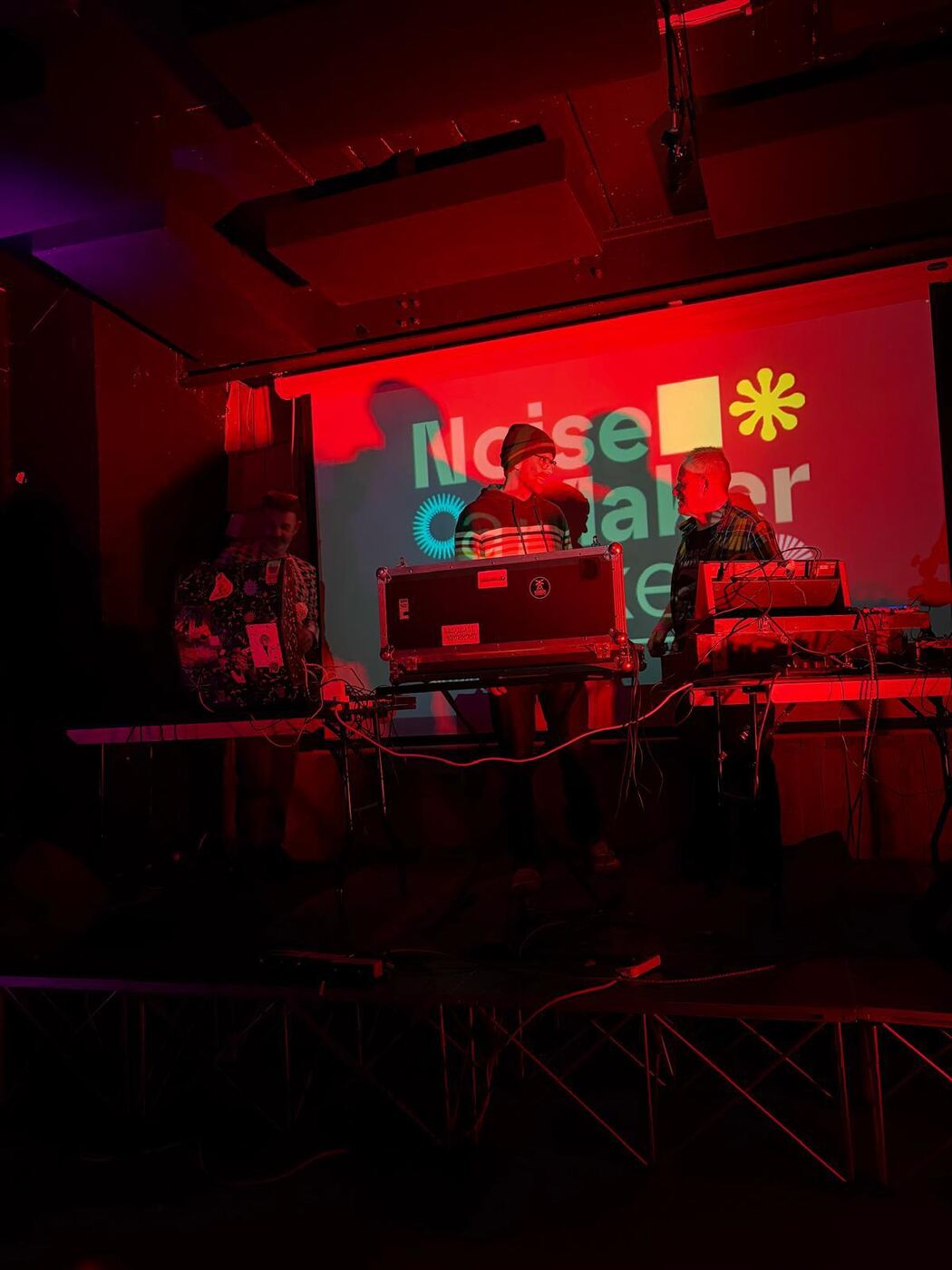 REEL performing live under red stage lighting