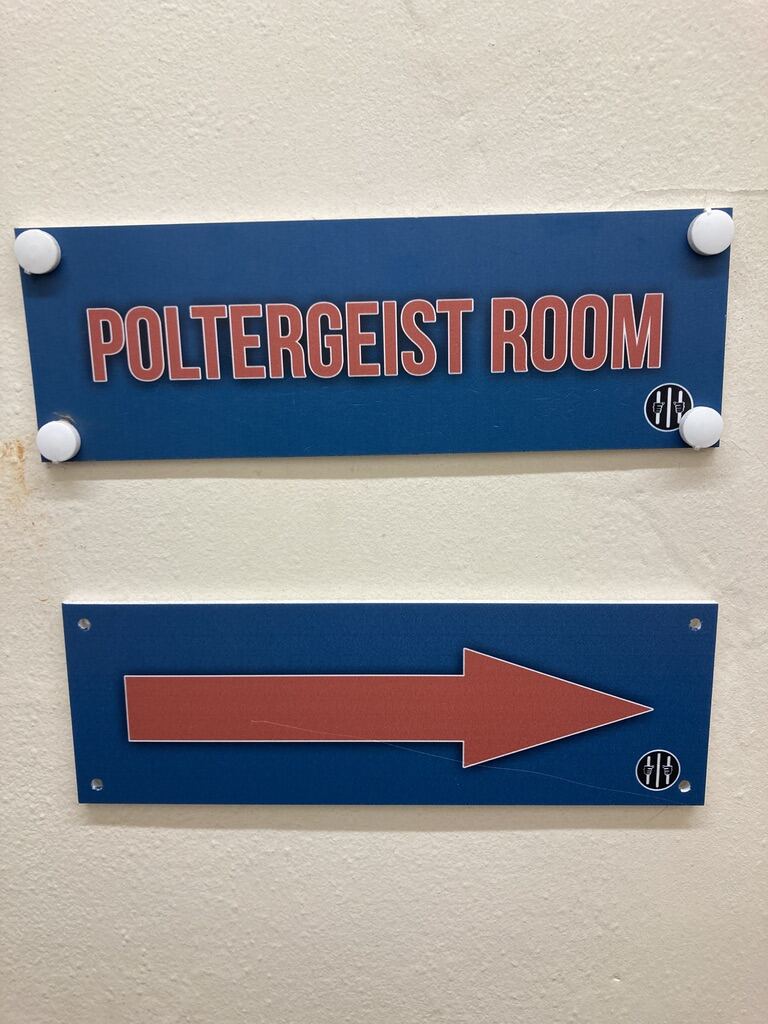 Sign reading Poltergeist Room with directional arrow